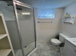 Lower level shared full bathroom with stall shower